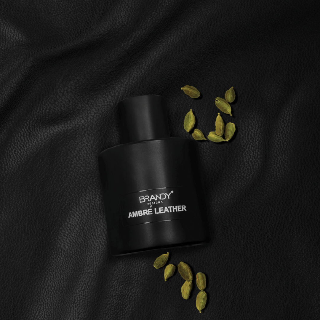 Black perfume bottle labeled 'Brandy' with cardamom pods on a black leather background