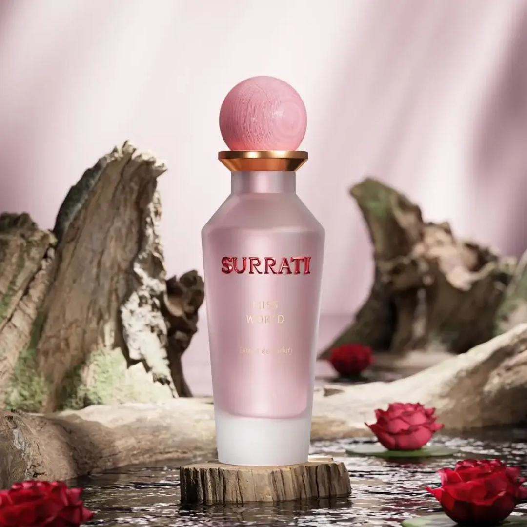 Pink Surrati perfume bottle with red roses on a natural background